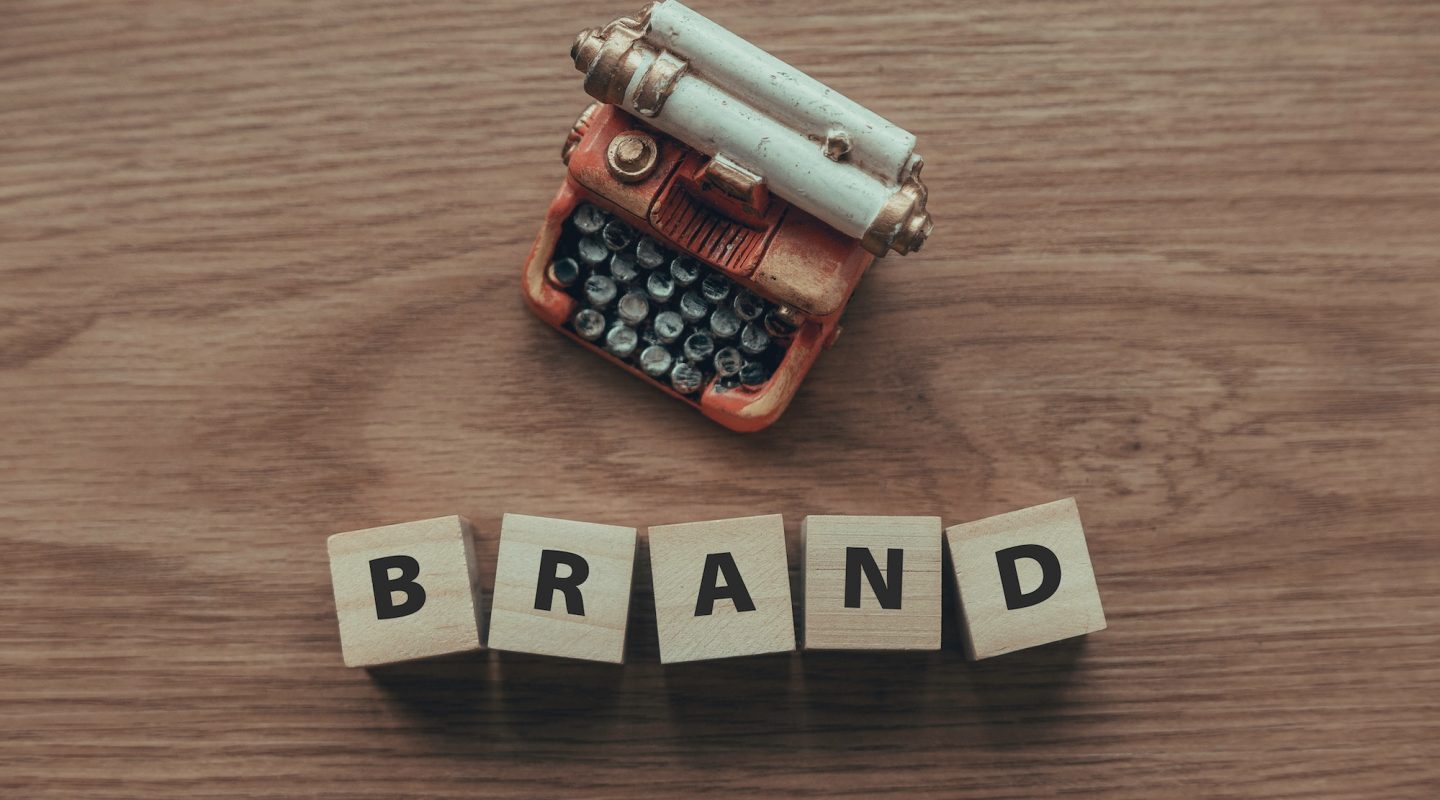 top-view-of-typewriter-and-wooden-cube-with-text-brand-on-wooden-background-.jpg